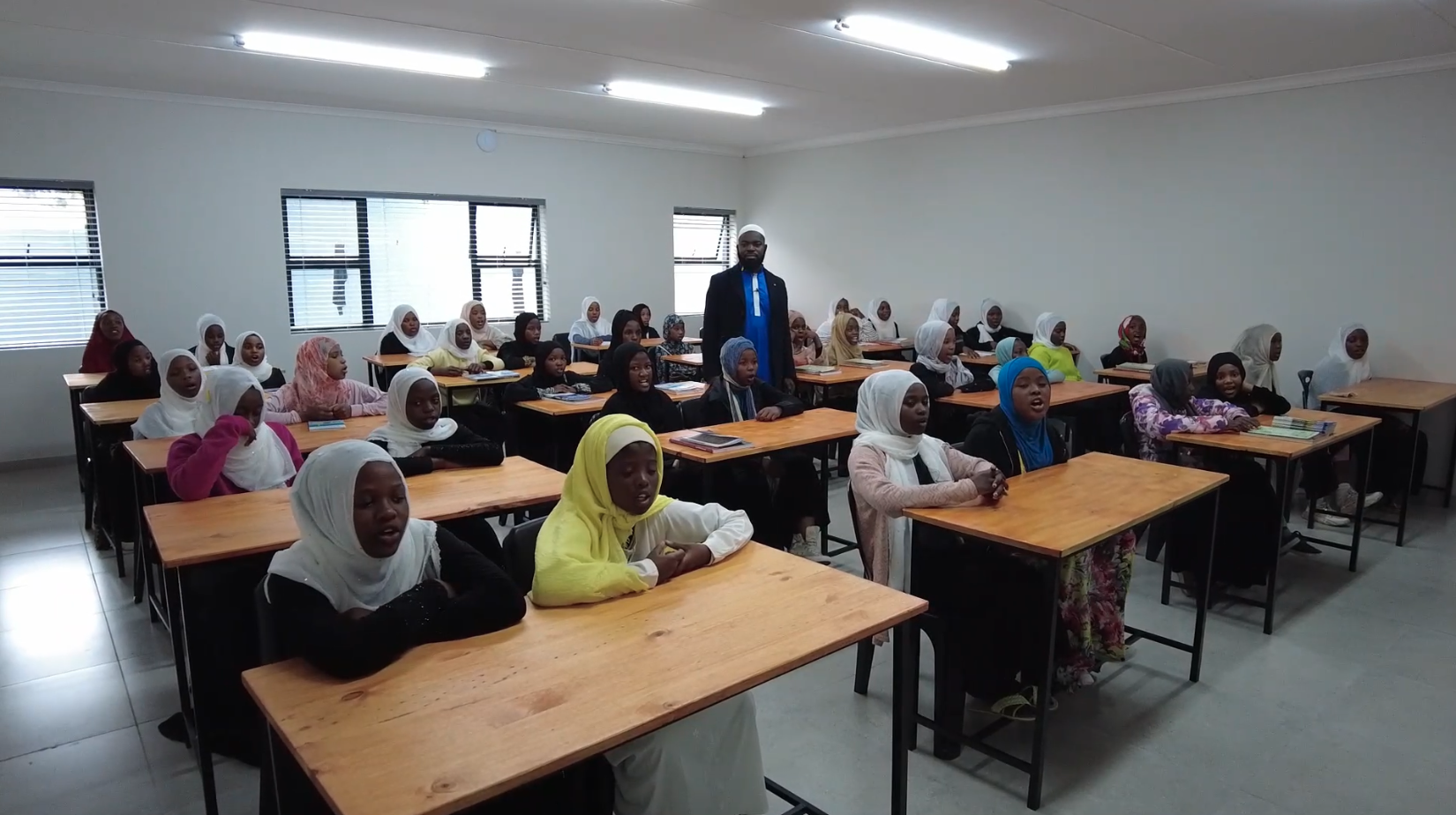 A group of annur new muslims learning quraan and spending quality learning time with their teacher